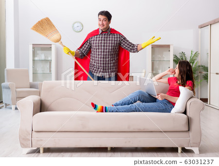 Superhero husband helping his wife at home Superhero husband helping his wife at home 63031237