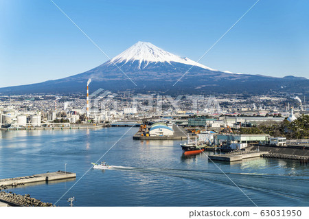 在一個陽光明媚的冬日里，從靜岡縣塔古那拉港（Tagonoura Port）眺望富士工業區和富士山。 63031950