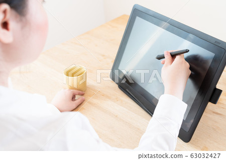 使用筆選項卡的年輕女子 使用筆選項卡的年輕女子 63032427