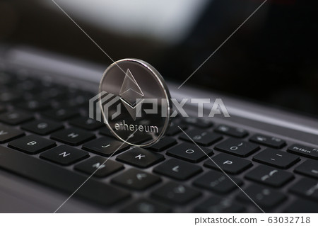 Silver ethereum coin is lying on laptop 63032718