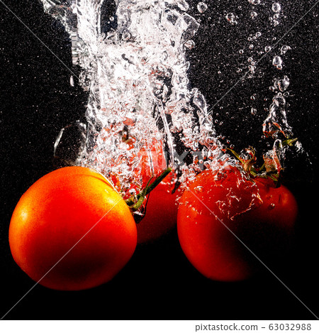Red tomatoes in water on a black background 63032988