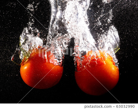 Red tomatoes in water on a black background Red tomatoes in water on a black background 63032990