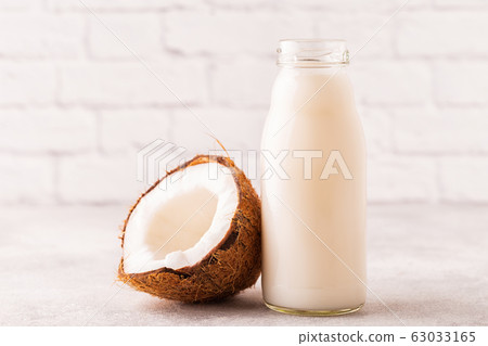 A bottle of coconut milk and coconut 63033165