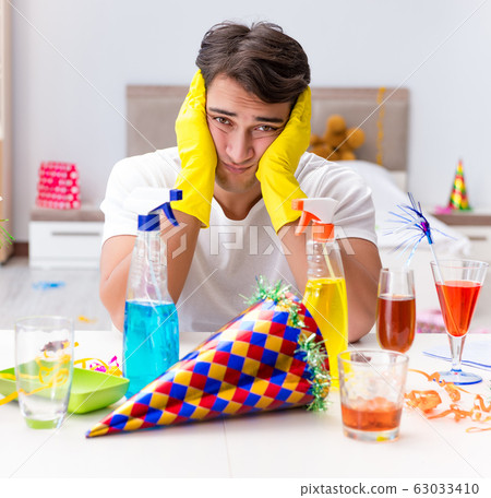 Man cleaning the house after christmas party 63033410
