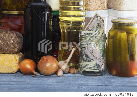 glass jar with paper dollars. against the glass jar with paper dollars. against the 63034012