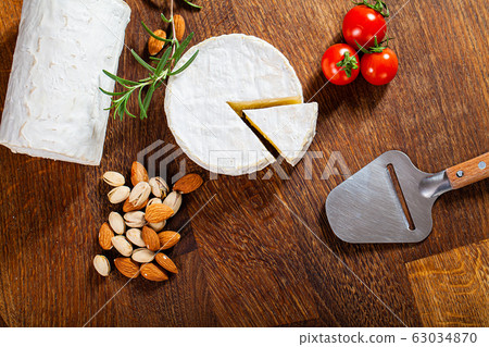 Camembert cheese or brie on wooden background. 63034870