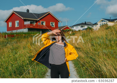 Girl in yellow jacket on the pathway to houses on Girl in yellow jacket on the pathway to houses on 63036287