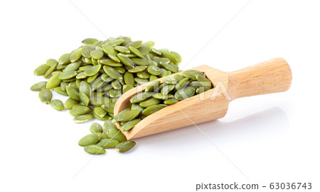 Pumpkin seeds in wood scoop isolated on a white Pumpkin seeds in wood scoop isolated on a white 63036743