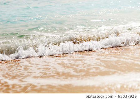 Powerful blue wave breaks along the shore. Close 63037929