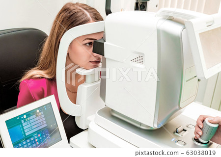Beautiful woman having an eye lens exam 63038019