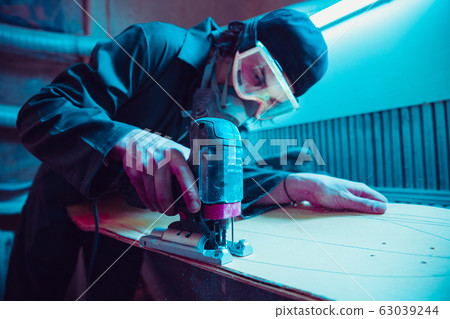 Skater in process of making his own skateboard, longboard - open business concept Skater in process of making his own skateboard, longboard - open business concept 63039244