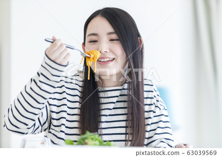 年輕女子微笑吃美味 63039569