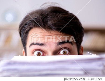 Businessman struggling to meet challenging deadlines Businessman struggling to meet challenging deadlines 63039721
