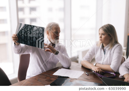Head doctor of the hospital department explains to his colleagues the result 63039990
