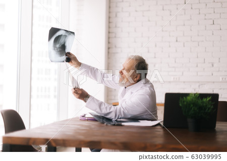 Chief Medical Officer of the department analyzing MRI scan results Chief Medical Officer of the department analyzing MRI scan results 63039995