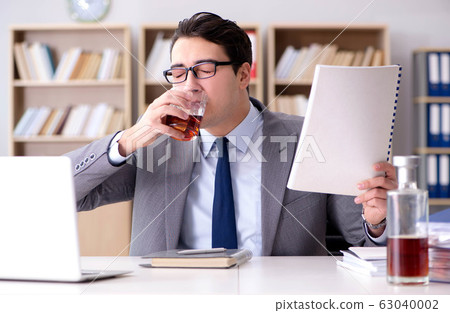 Young businessman drinking from stress 63040002