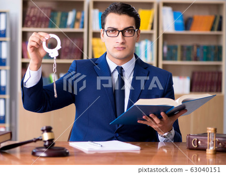 Handsome judge with gavel sitting in courtroom 63040151