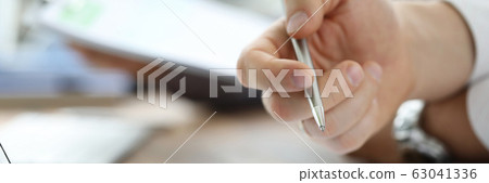 Group of people working with financial reports clipped to pad at workplace Group of people working with financial reports clipped to pad at workplace 63041336