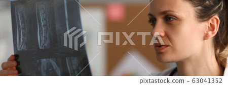 Professional female doctor hold x-ray imge in hand Professional female doctor hold x-ray imge in hand 63041352