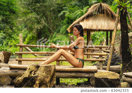 Relaxed brunette girl sitting in semi position Relaxed brunette girl sitting in semi position 63042355