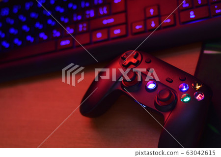 Modern gamepad lies with pc keyboard on table in 63042615