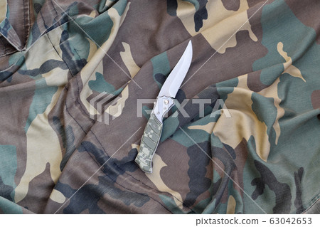 Military knife on army camouflage clothes close Military knife on army camouflage clothes close 63042653