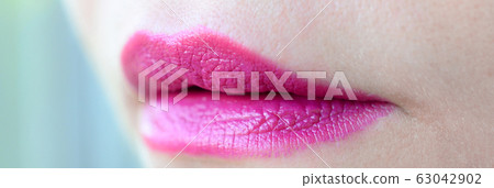 Close up shot of woman lips with glossy fuchsia 63042902