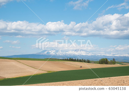 Mountain ranges of remaining snow and spring fields 63045138
