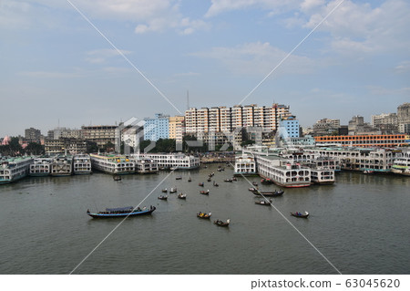 Cityscape around Shor Gat, Dhaka, Bangladesh, a small boat traveling with a medium-sized boat stopped on the Brigonga River 63045620