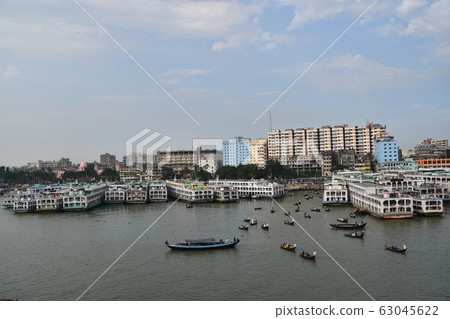 Cityscape around Shor Gat, Dhaka, Bangladesh, a small boat traveling with a medium-sized boat stopped on the Brigonga River 63045622