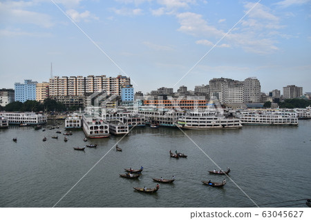 Cityscape around Shor Gat, Dhaka, Bangladesh, a small boat traveling with a medium-sized boat stopped on the Brigonga River 63045627