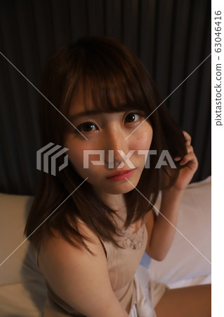 每天,一個單獨生活在城市的女大學生的房間穿著。一個女孩在她的臥室裡放鬆的20多歲的真實面孔。 每天,一個單獨生活在城市的女大學生的房間穿著。一個女孩在她的臥室裡放鬆的20多歲的真實面孔。 63046416