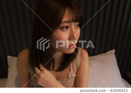每天,一個單獨生活在城市的女大學生的房間穿著。一個女孩在她的臥室裡放鬆的20多歲的真實面孔。 每天,一個單獨生活在城市的女大學生的房間穿著。一個女孩在她的臥室裡放鬆的20多歲的真實面孔。 63046423