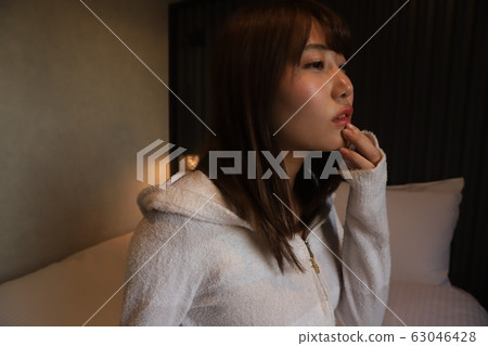 Daily, room wear of a female college student living alone in the city. The real face of a girl in her 20s relaxing in her bedroom. Daily, room wear of a female college student living alone in the city. The real face of a girl in her 20s relaxing in her bedroom. 63046428