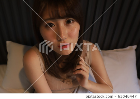 Daily, room wear of a female college student living alone in the city. The real face of a girl in her 20s relaxing in her bedroom. Daily, room wear of a female college student living alone in the city. The real face of a girl in her 20s relaxing in her bedroom. 63046447