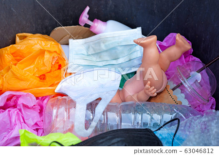 Dirty used surgical masks in a garbage bin. 63046812