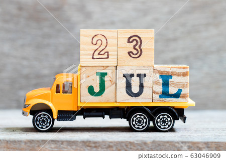 Truck hold letter block in word 23jul on wood background  63046909