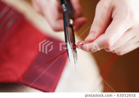 A leather craftsman works with leather. Sews A leather craftsman works with leather. Sews 63052658