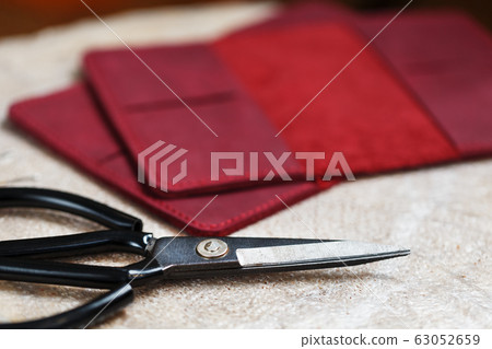 A leather craftsman works with leather. Sews A leather craftsman works with leather. Sews 63052659