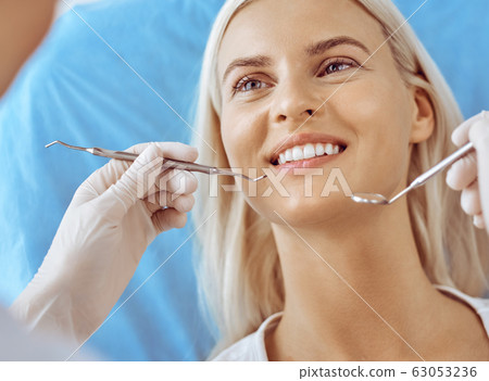 Smiling blonde woman examined by dentist at dental clinic. Healthy teeth and medicine concept 63053236