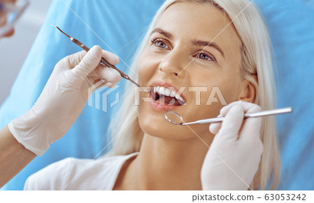 Smiling blonde woman examined by dentist at dental clinic. Healthy teeth and medicine concept 63053242