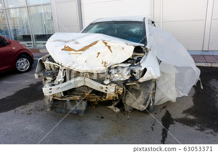 Seriously damaged vehicle near car service 63053371