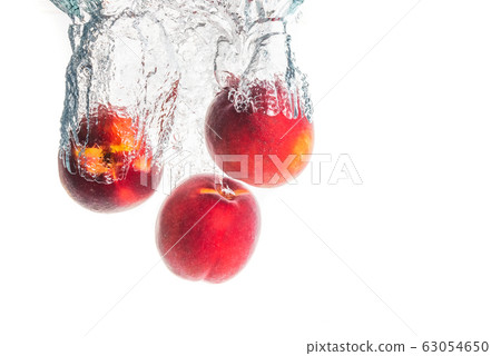 Nectarine fruits splashing into water and sinking Nectarine fruits splashing into water and sinking 63054650