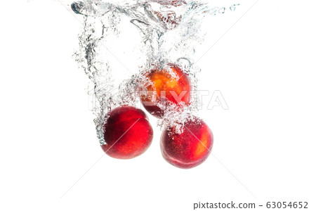 Nectarine fruits splashing into water and sinking Nectarine fruits splashing into water and sinking 63054652
