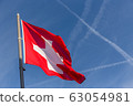swiss cross flag waving with crossing flight trail 63054981