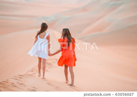 Girls among dunes in Rub al-Khali desert in United Arab Emirates 63056087