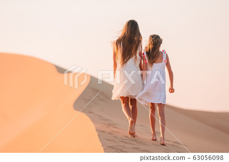 Girls among dunes in Rub al-Khali desert in United Arab Emirates 63056098