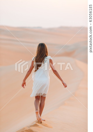 Girl among dunes in desert in United Arab Emirates Girl among dunes in desert in United Arab Emirates 63056185