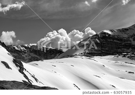 Snowy rocks and cloudy sky at evening mountains Snowy rocks and cloudy sky at evening mountains 63057935