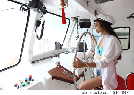 Captain Lady in Bikini and hat control Ship Steer 63058475